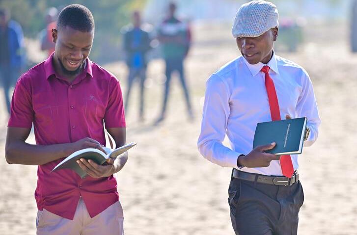 Two Men holding and reading the Bible in Kwamashi